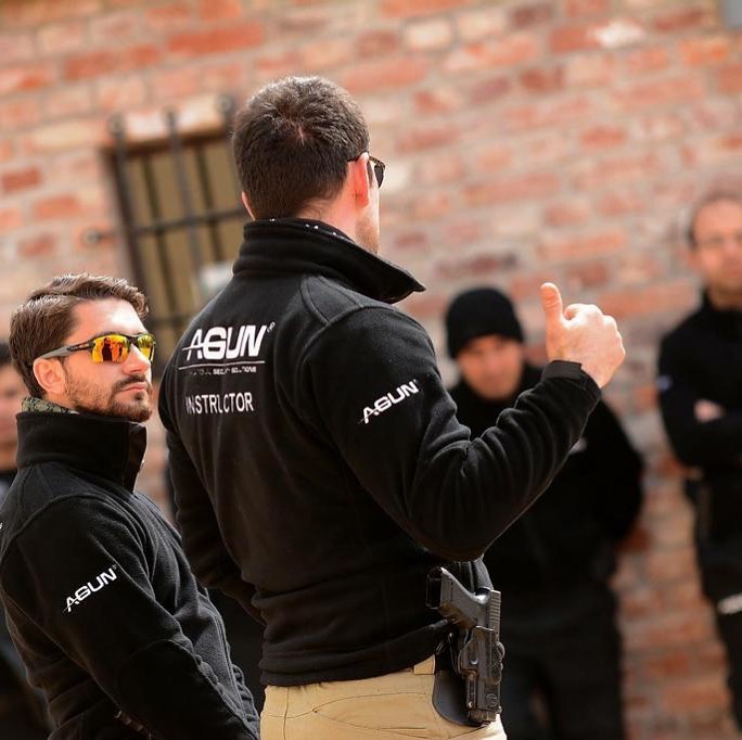 Instructor briefing trainees in the yard before a firearms session