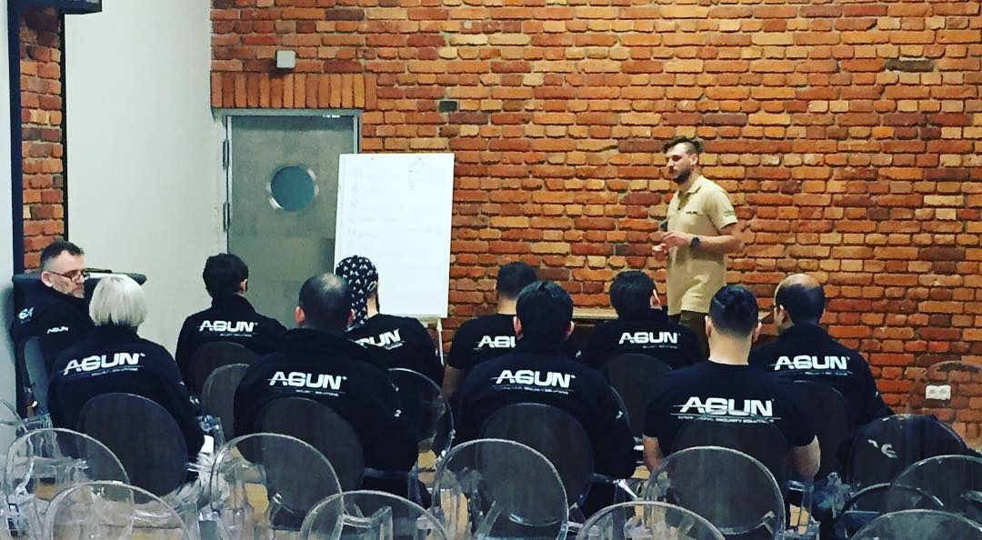 Trainees seated for a classroom lecture in front of a flip chart