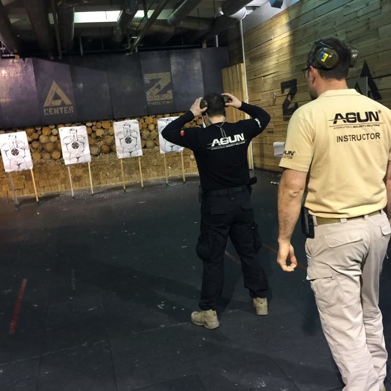 Instructor watching a trainee on the pistol range