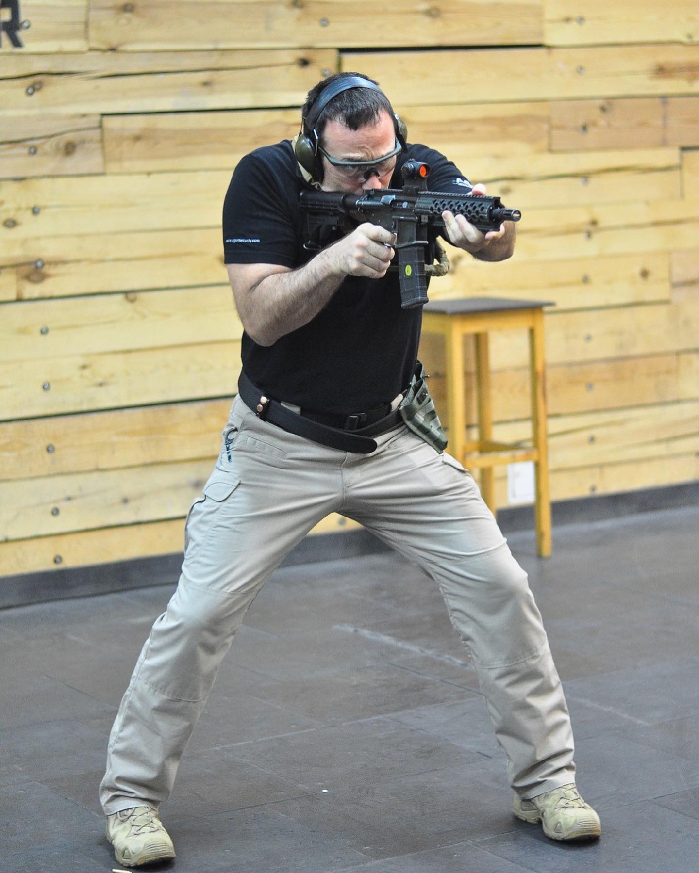 Instructor in a low stance firing a carbine on the indoor range