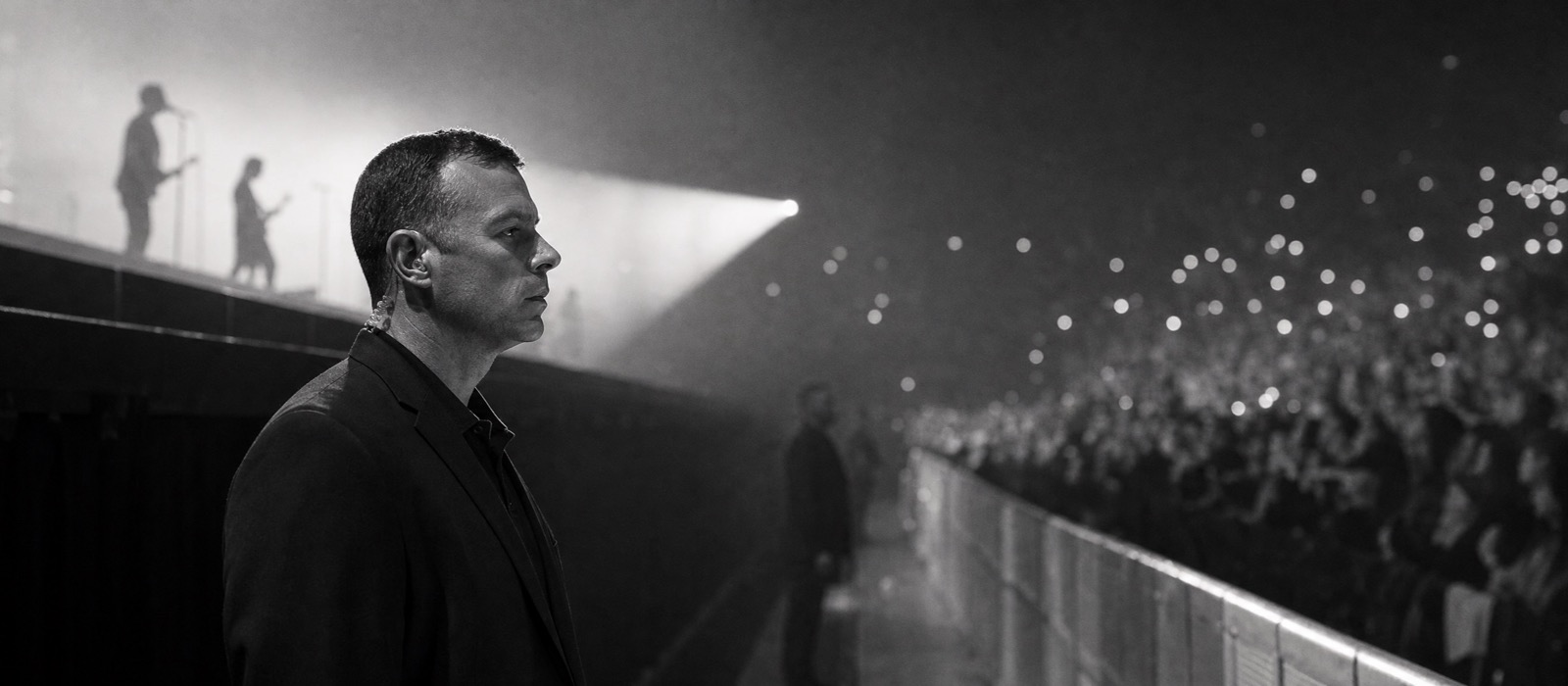 Event security officer watching the crowd from the stage barrier during a concert